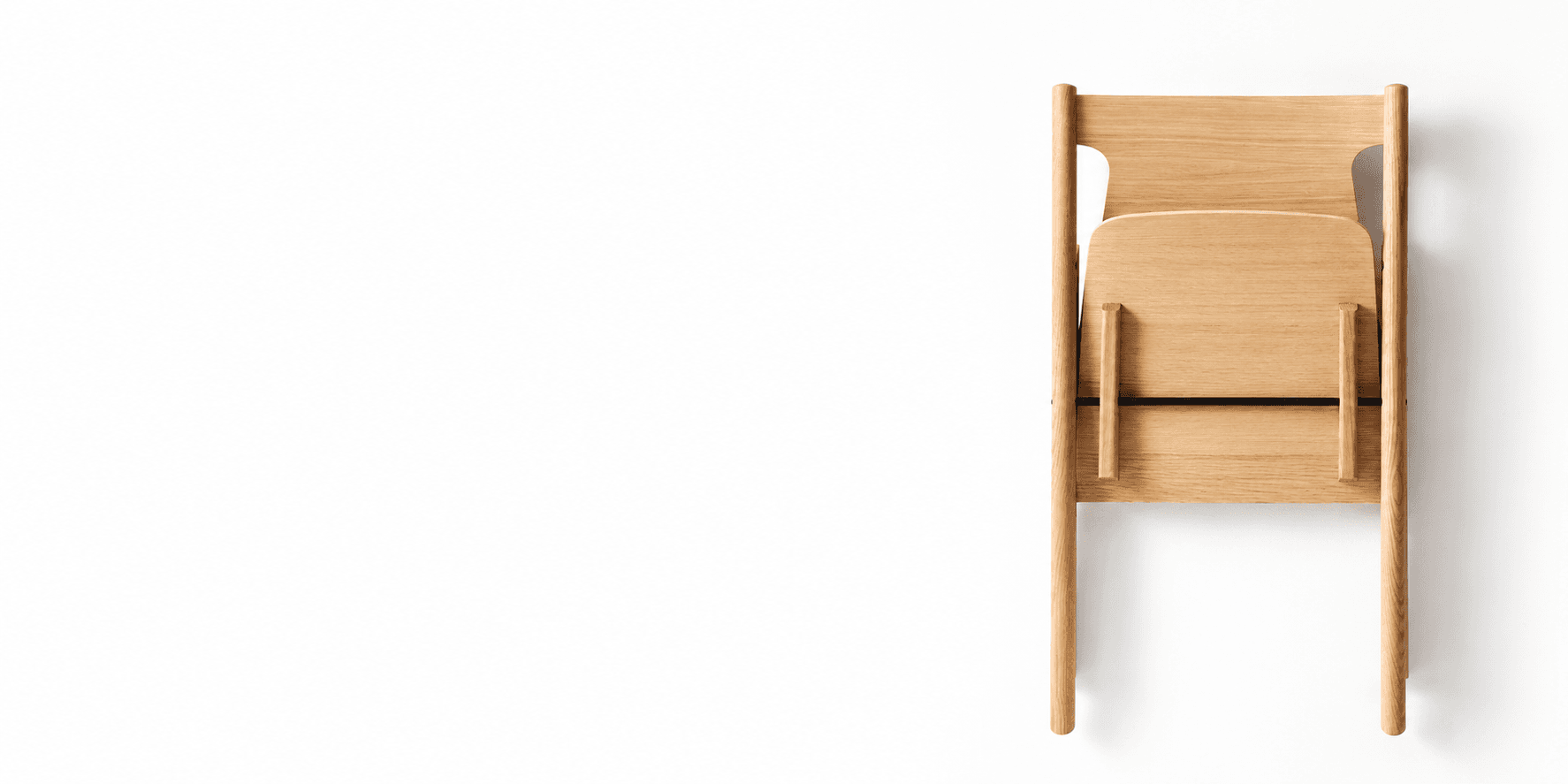 A solid-oak dining chair seen from above against white