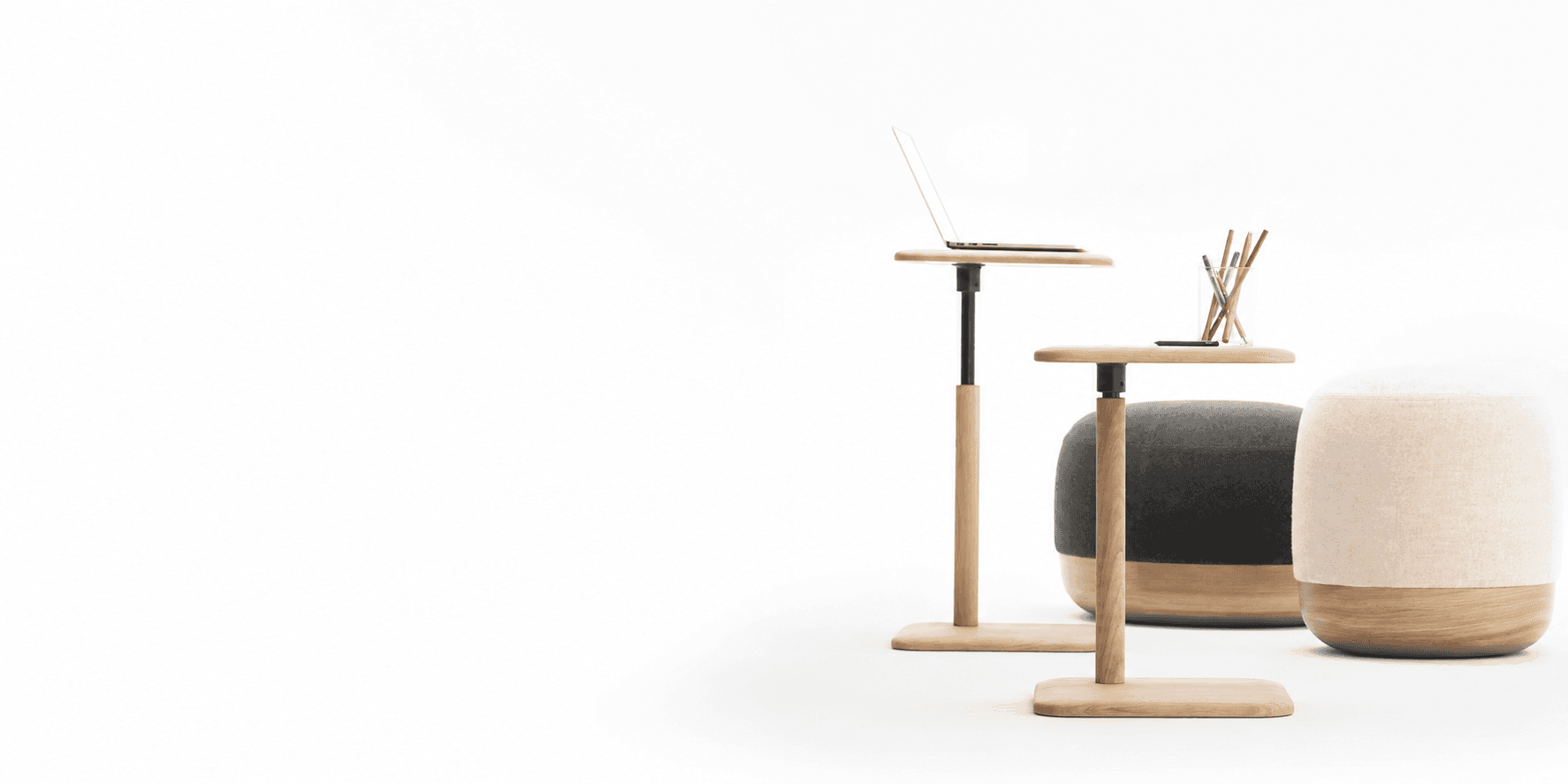 Height-adjustable oak side tables beside upholstered poufs